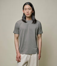 Load image into Gallery viewer, Model wearing Merz B. Schwanen - Good Basics Unisex T-shirt in Vintage Army.