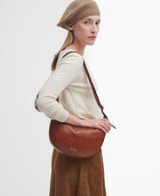 Load image into Gallery viewer, Model wearing Barbour Laire Leather Sling Bag in Brown.
