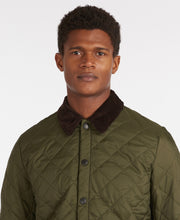 Load image into Gallery viewer, Model wearing Barbour Heritage Liddesdale Quilt in Olive.
