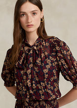 Load image into Gallery viewer, Model working Polo Ralph Lauren - Floral Tie-Neck Georgette Dress in Fall Poppy Floral.
