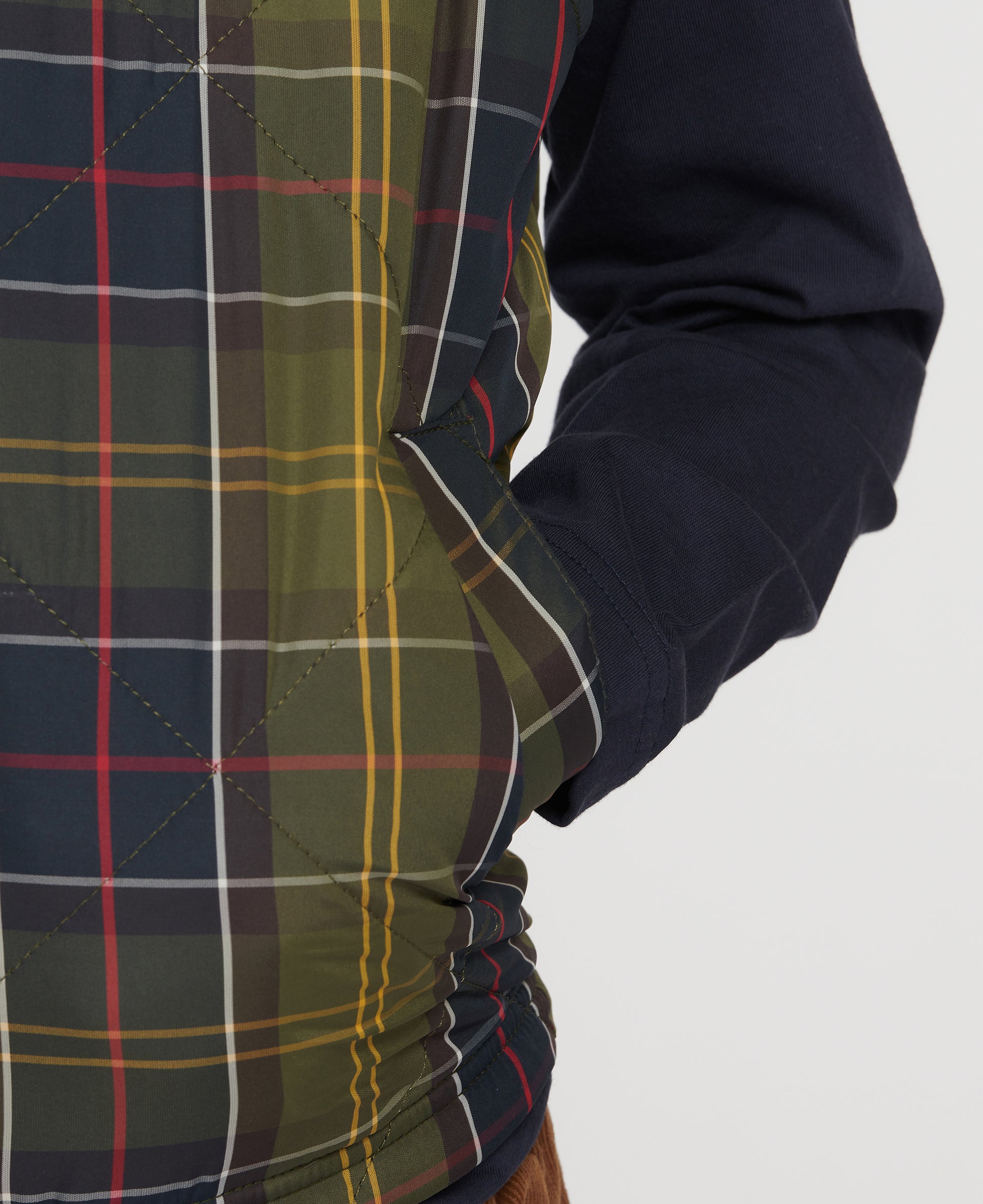 Model wearing Barbour Finn Youth Gilet in Classic Tartan.