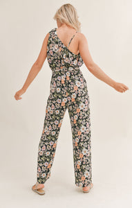 Model wearing Sadie & Sage - Getaway Garden One Shoulder Jumpsuit in Black Multi - back.