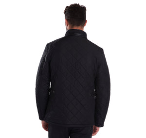 Back of model wearing Barbour Powell Quilt jacket in black.